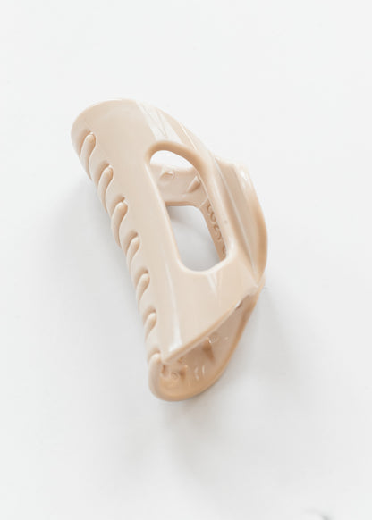 Creamy blonde flexible claw clip angled to show curved teeth and open center construction.
