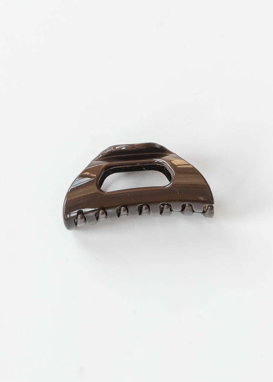 Espresso brown flexible claw clip with curved teeth and open center detail on a white background.

