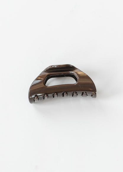 Espresso brown flexible claw clip with curved teeth and open center detail on a white background.
