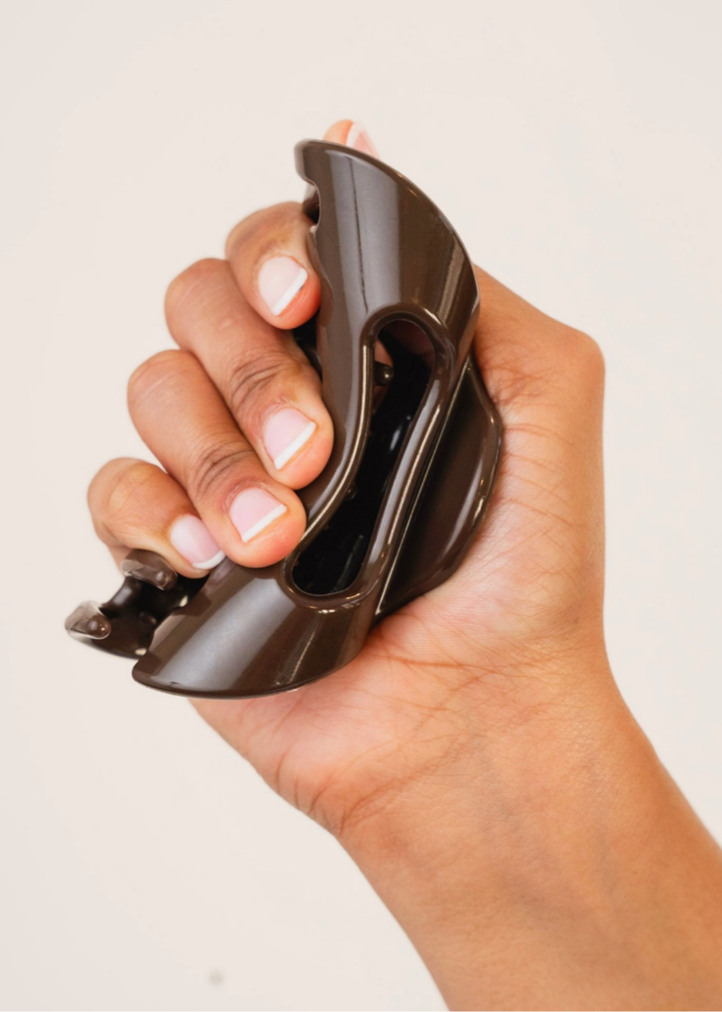 Espresso flexible claw clip bent in hand to show its soft, bendable construction.