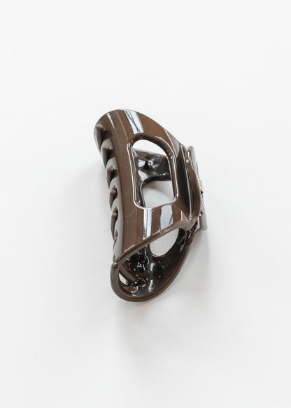 Glossy espresso claw clip angled to show its curved shape, spring closure, and open center.
