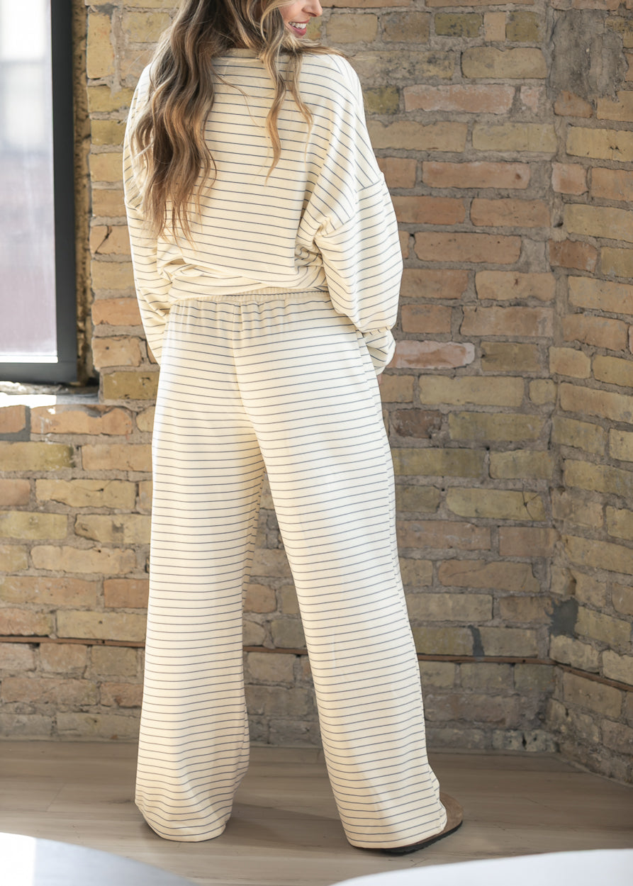 Back of ivory striped wide leg pants showing the relaxed silhouette and fully elastic waistband.