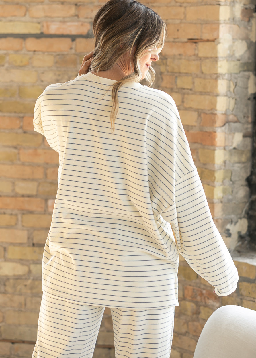 Back of ivory striped oversized long sleeve top showing the relaxed drape and longer length.