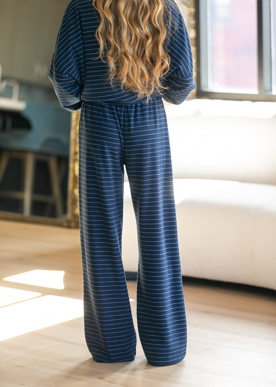 Back of navy striped wide leg pants showing the relaxed silhouette and elastic waistband.