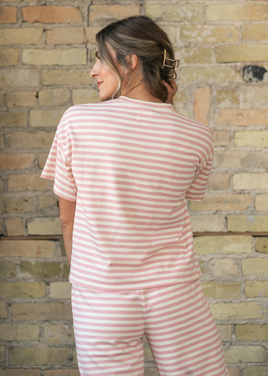 Back of pink striped tee showing oversized boxy fit and hip-length hem.