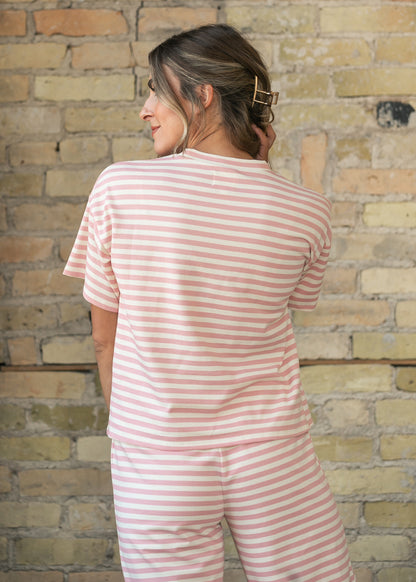 Back of pink striped tee showing oversized boxy fit and hip-length hem.