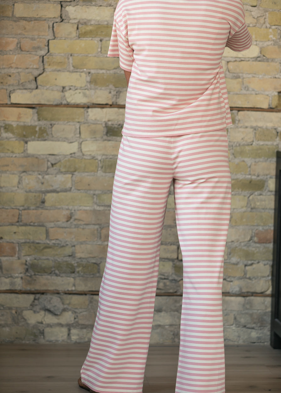 Back of pink striped relaxed pants showing the full-length wide-leg fit.