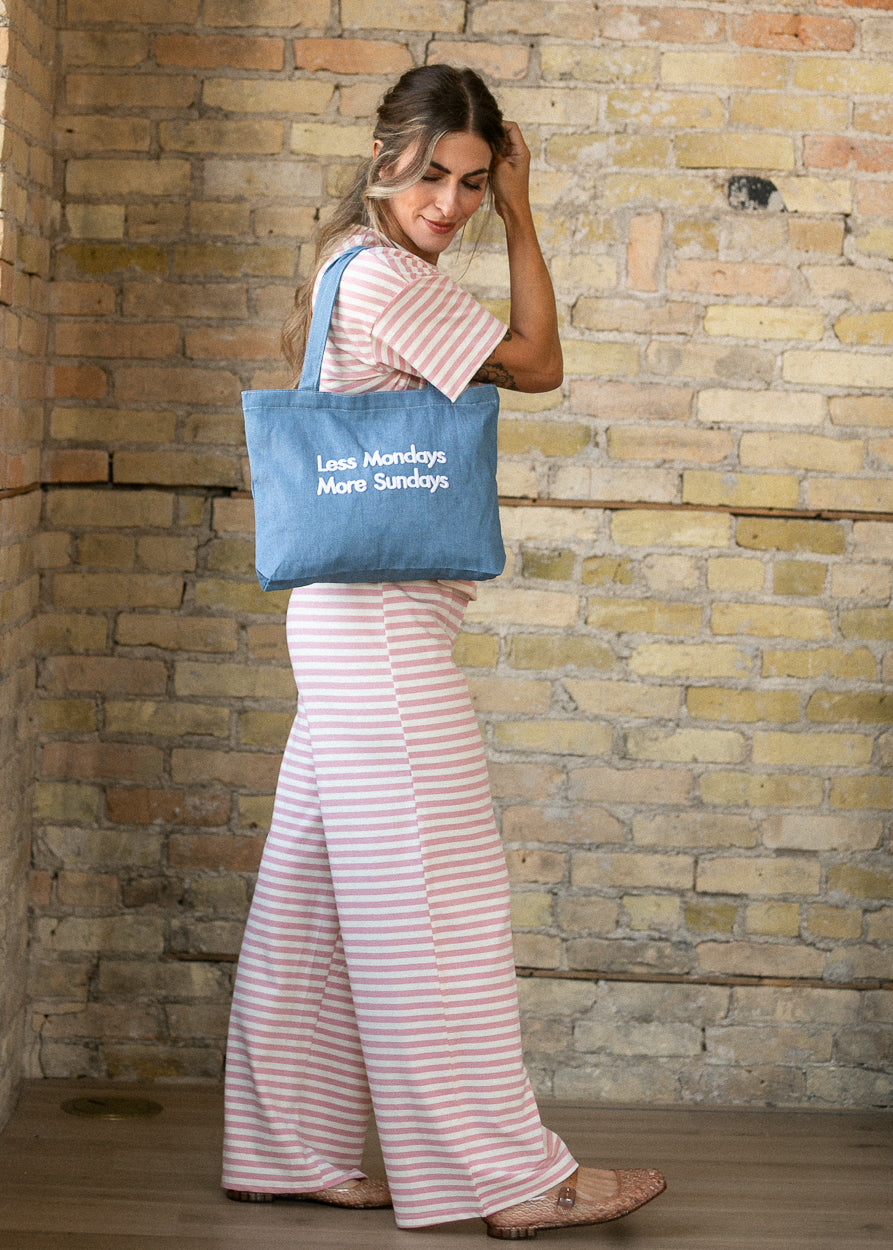 Pink striped relaxed pants styled with the matching tee and blue denim tote.