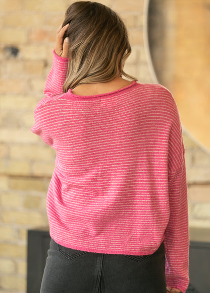 Back of bubblegum pink striped cardigan showing relaxed fit, dropped shoulders, and hip-length hem.