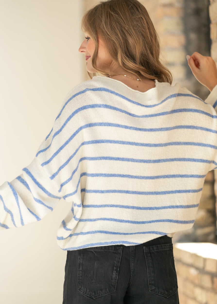Back of the ivory and blue striped Piper cardigan highlighting the ribbed hem and drop-shoulder fit.