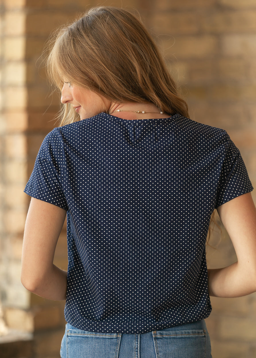 Back of navy polka dot jersey short sleeve tee showing the loose hip-length fit and allover print.