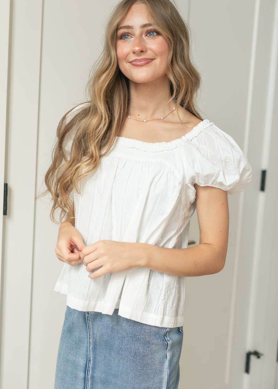 Side view of white cotton puff sleeve top with textured woven detail