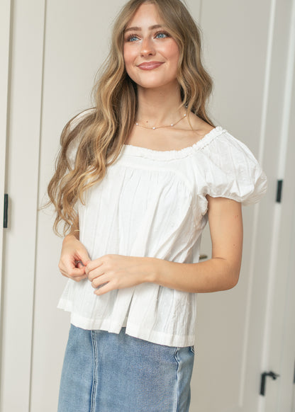 Side view of white cotton puff sleeve top with textured woven detail