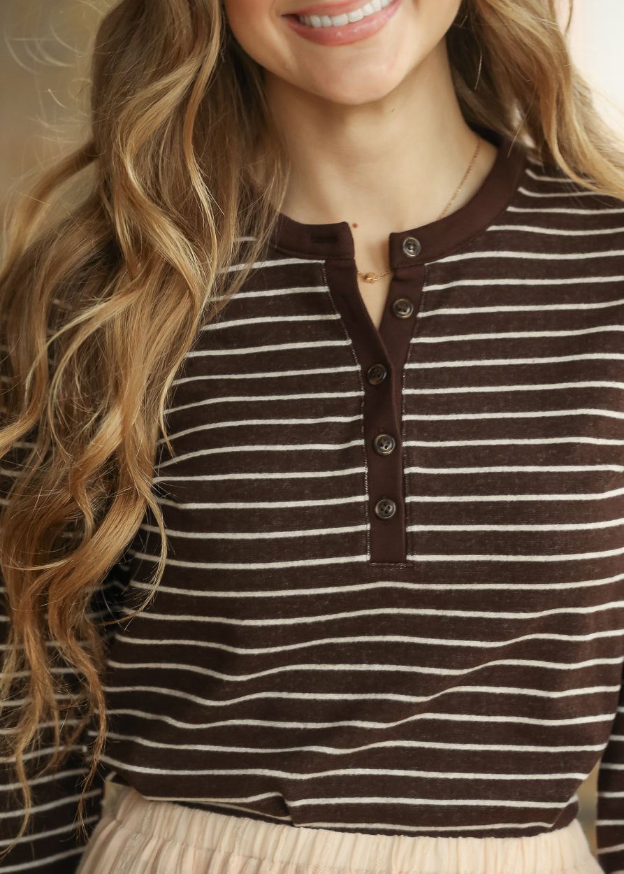 Close-up of brown striped top showing long sleeve and contrast ribbed cuff.