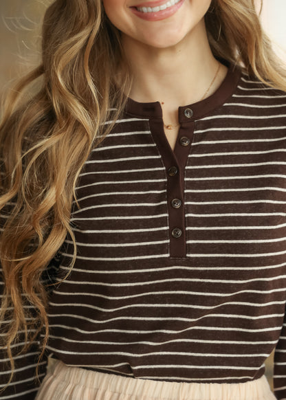 Close-up of brown striped top showing long sleeve and contrast ribbed cuff.