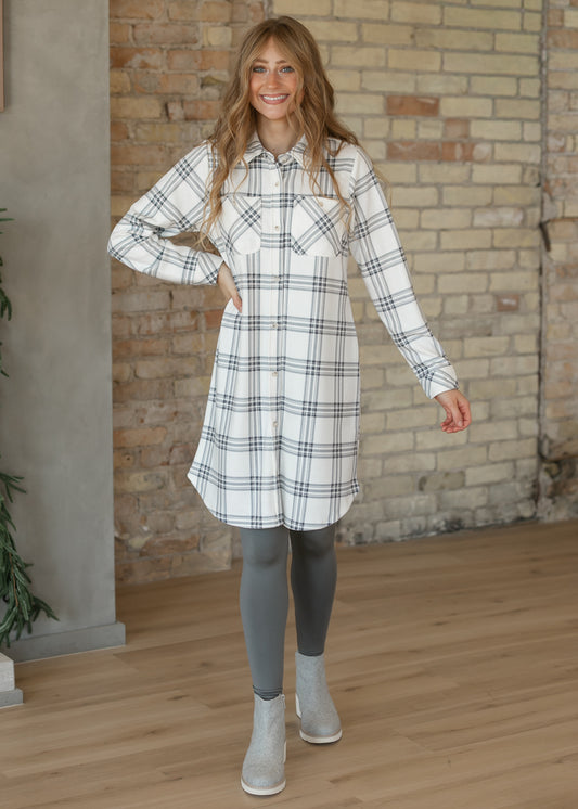 Ivory and charcoal plaid shirt dress with functional front buttons, chest flap pockets, and a relaxed silhouette.