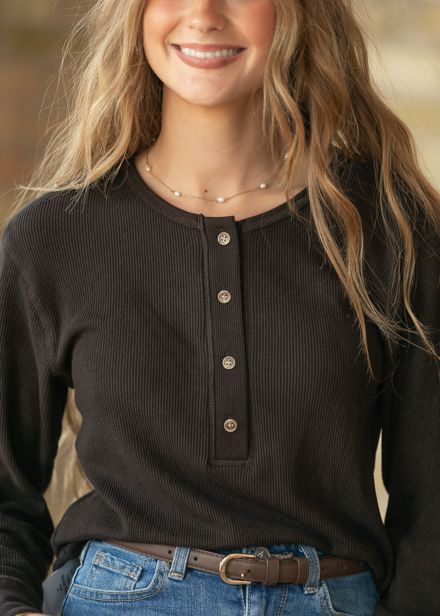 Close-up of espresso ribbed henley top showing round neckline, button placket, and ribbed texture.