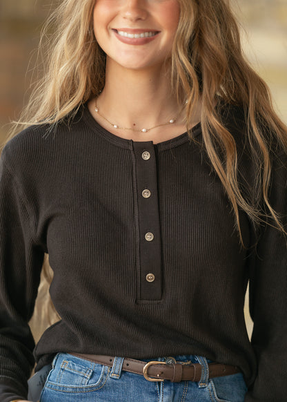 Close-up of espresso ribbed henley top showing round neckline, button placket, and ribbed texture.