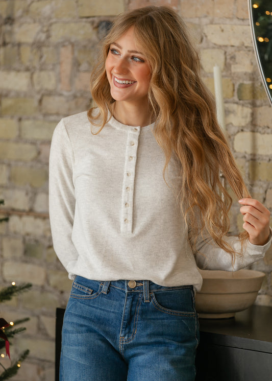 Heather gray long sleeve Henley top tucked into medium wash denim jeans, showing the relaxed silhouette.