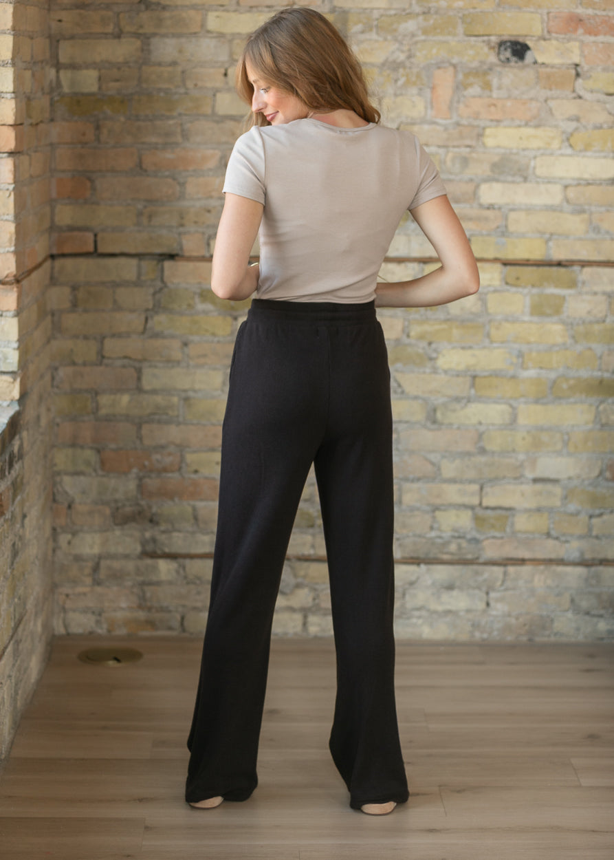 Back of espresso wide leg pants showing the relaxed wide leg silhouette and floor-length fit.