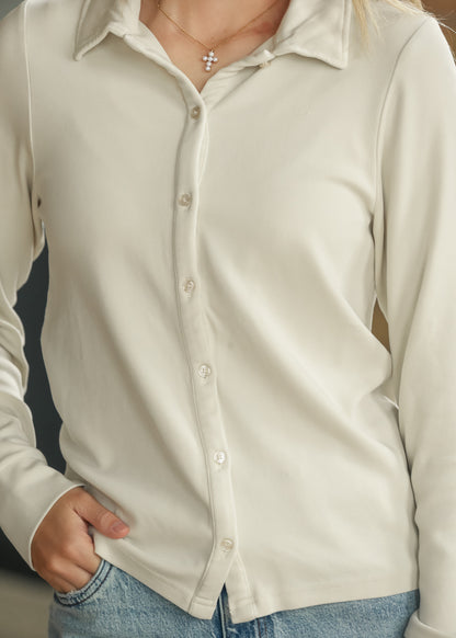 Close-up of cream button-up shirt showing functional tonal buttons and soft fabric.