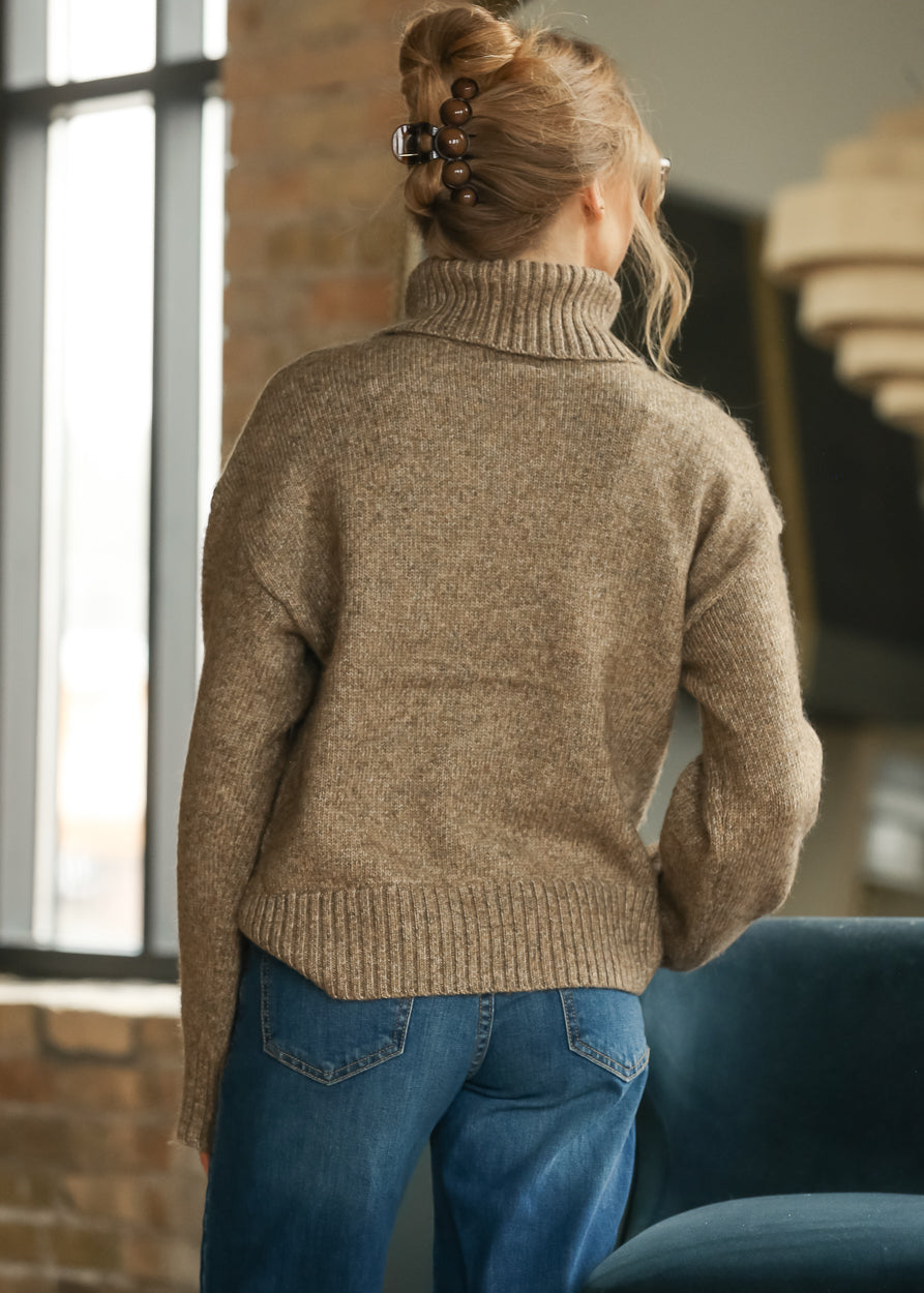Back of sandstone knit sweater showing relaxed shape, dropped shoulders, and ribbed hem.