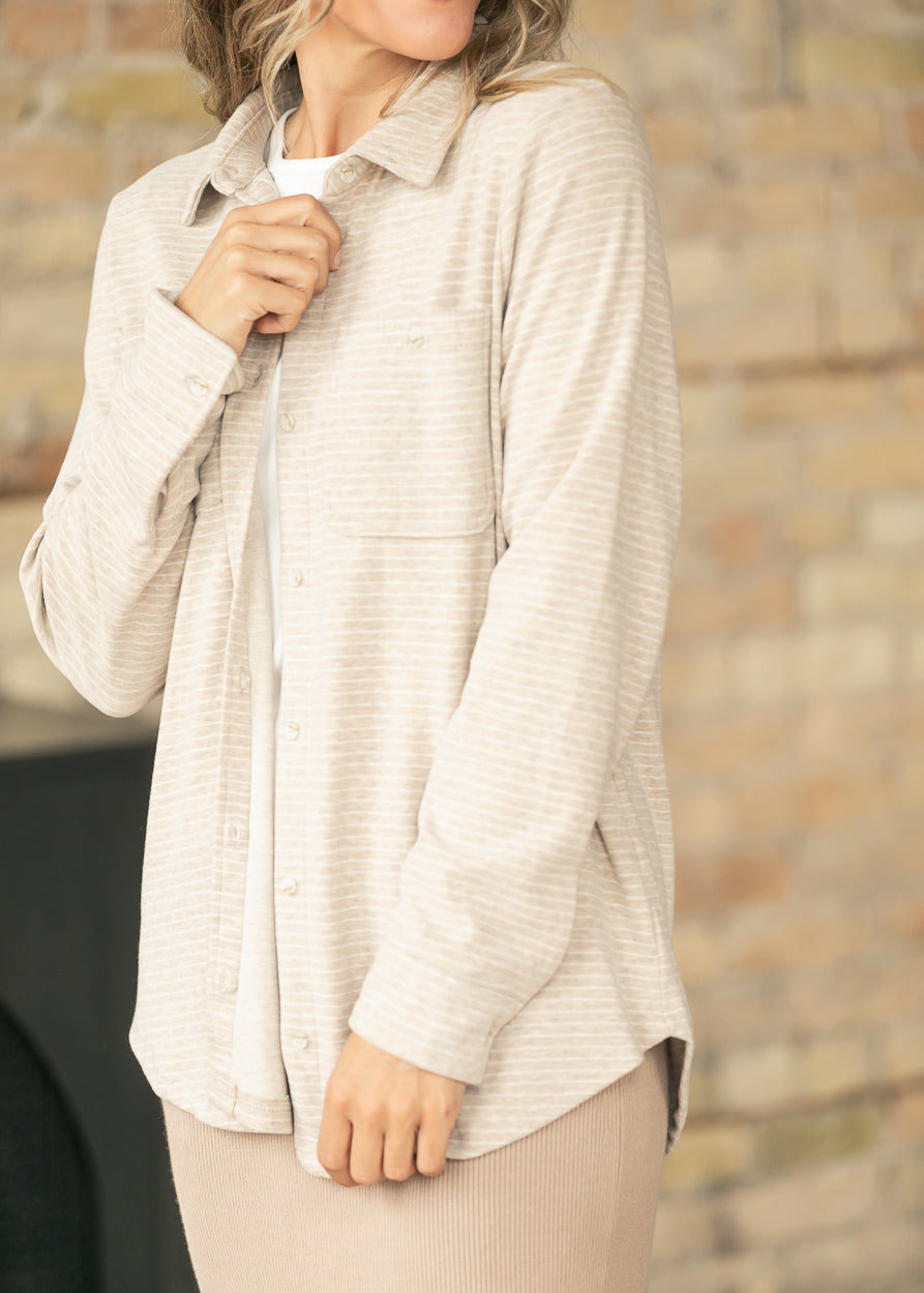 Close-up of tan striped shirt fabric and pocket detail, styled over a white tee.