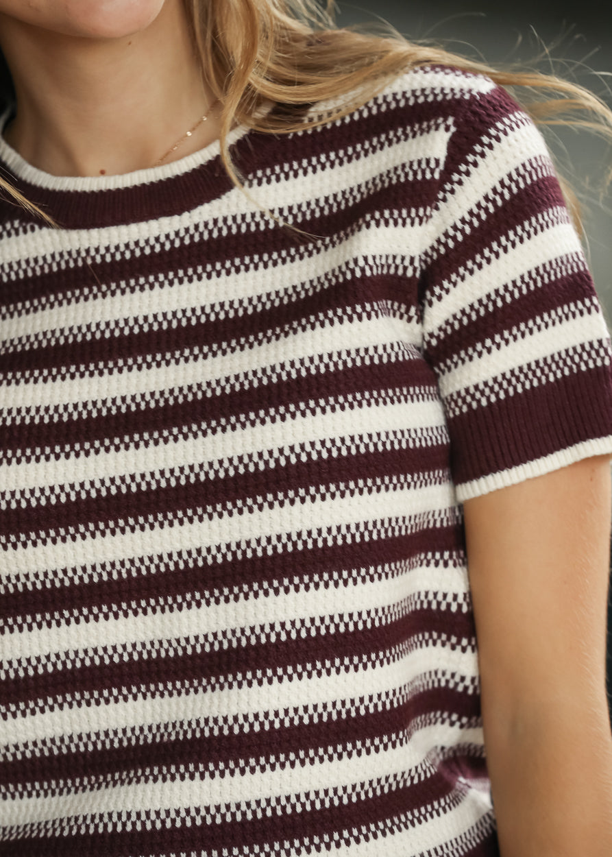 Close-up maroon and cream striped Welles knit top with short sleeves and textured stitch detail.