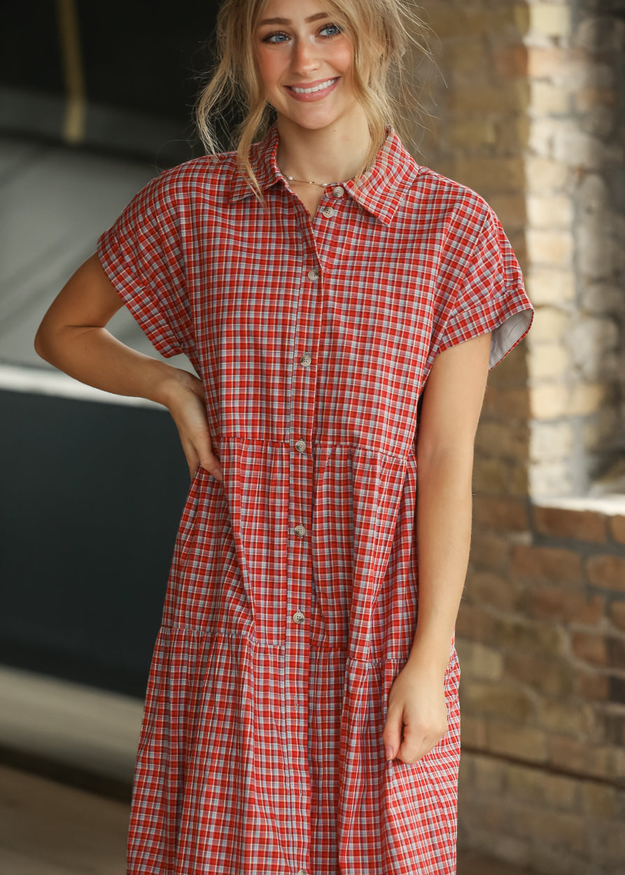 Red gingham tiered dress with functional buttons and side pockets, shown from the front.