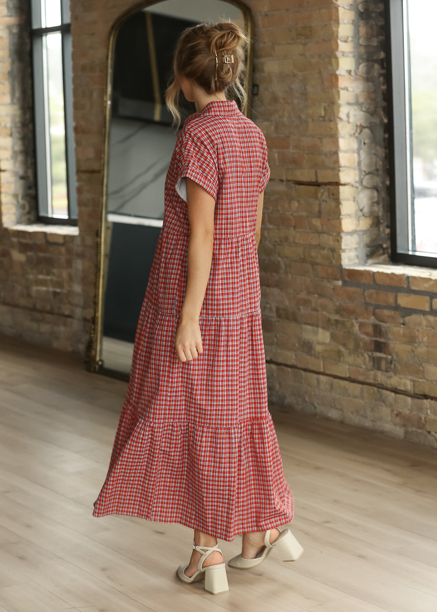 Back of red gingham tiered midi dress showing the collared neckline, short sleeves, and full skirt.