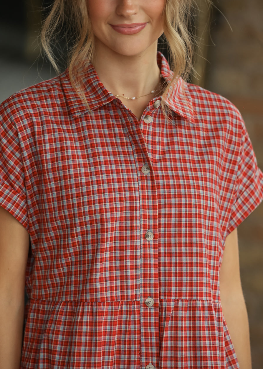 Close-up of red gingham dress showing the collared neckline and functional front buttons.