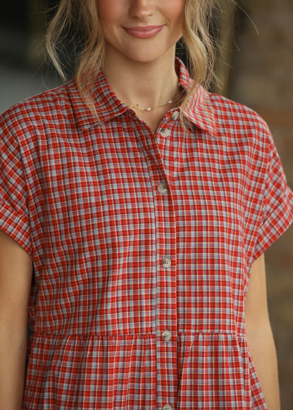 Close-up of red gingham dress showing the collared neckline and functional front buttons.
