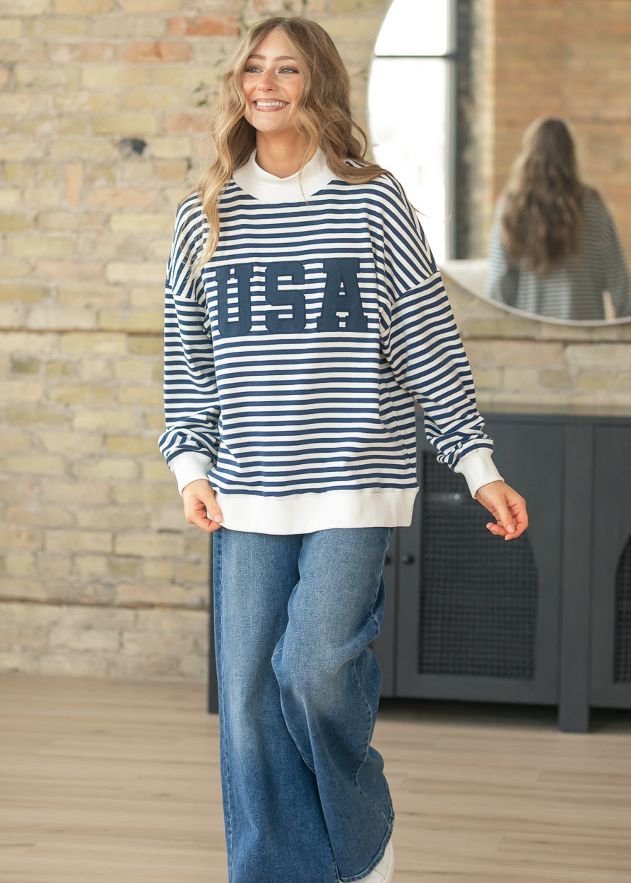 Front view of oversized USA sweatshirt styled with wide leg denim jeans