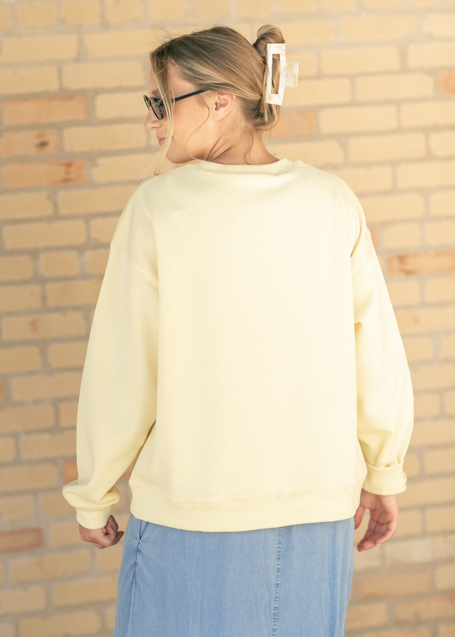 Back of butter yellow oversized crewneck sweatshirt with ribbed hem and cuffs.
