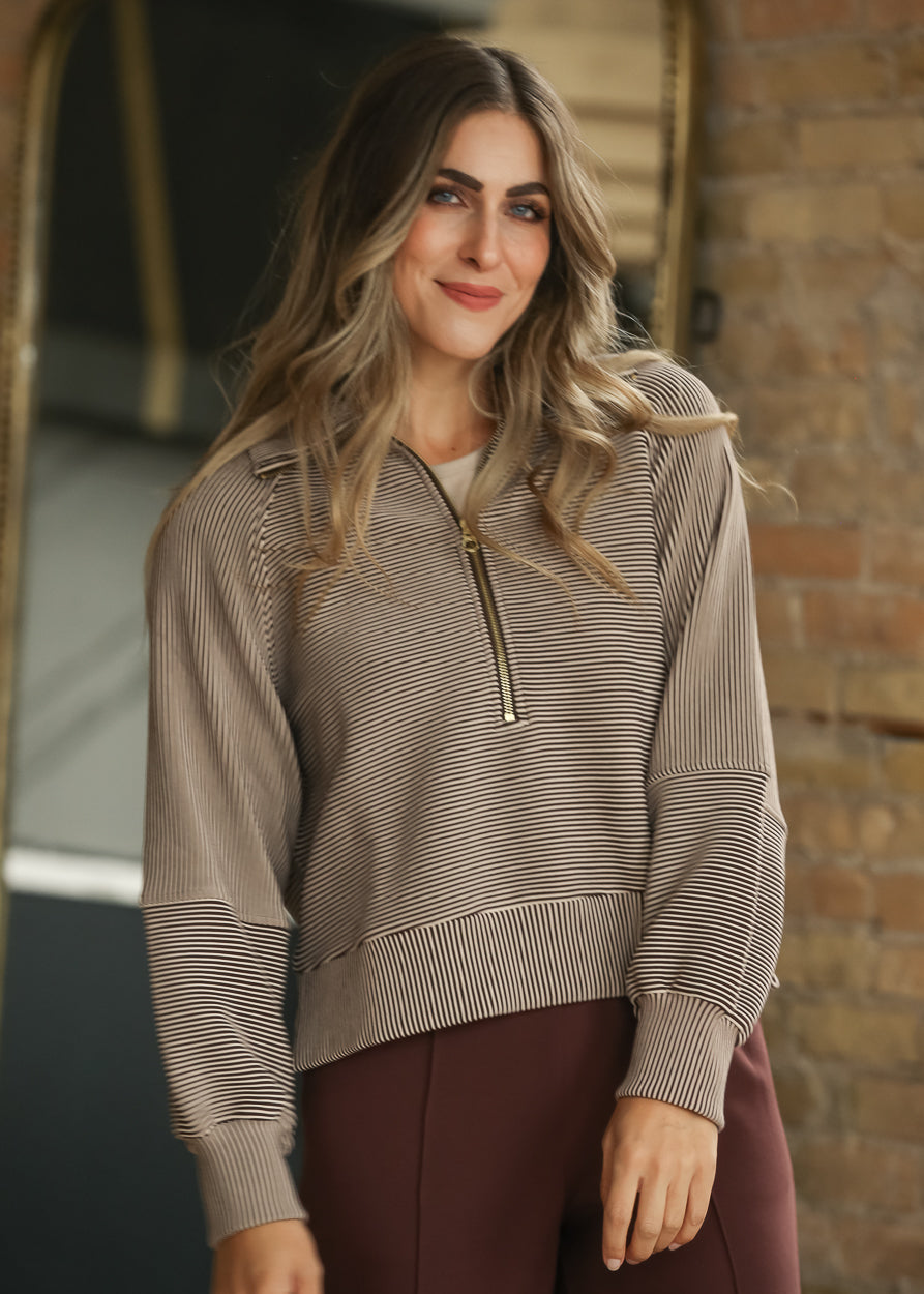 Brown and cream striped Varley half zip pullover with long sleeves and relaxed fit.