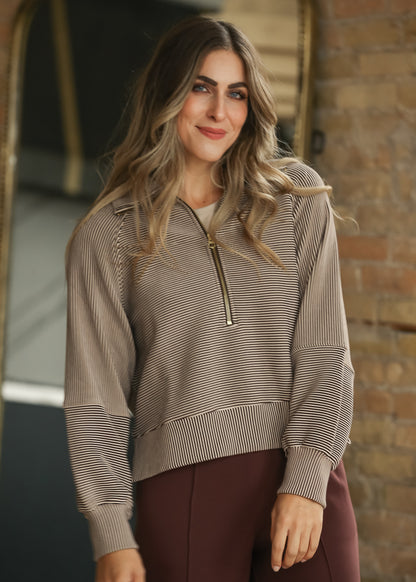 Brown and cream striped Varley half zip pullover with long sleeves and relaxed fit.