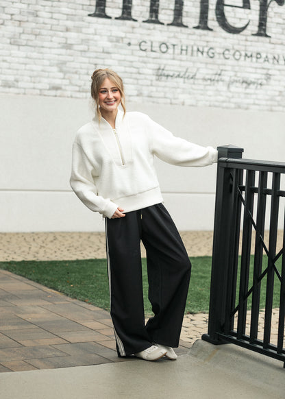 Varley cream Mumford half zip fleece styled with black wide-leg pants