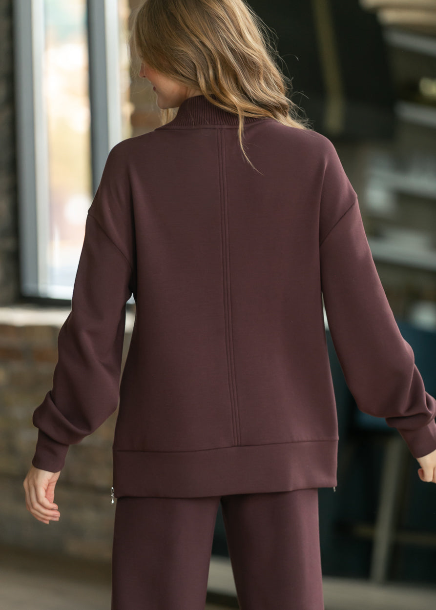 Back of chocolate brown Varley Novi sweatshirt showing longline fit, drop shoulders, and center seam.