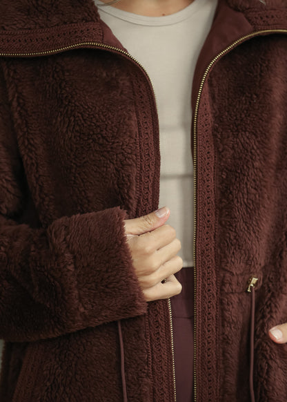 Close-up of mahogany sherpa texture, wide collar, gold-tone zipper, and drawstring waist.