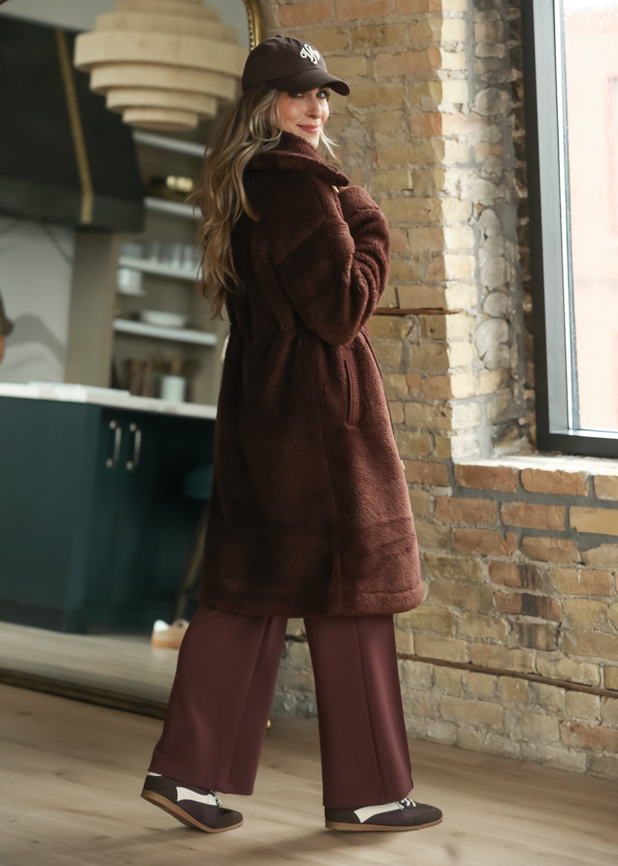Side and back view of mahogany long sherpa coat showing its loose fit and knee-length cut.