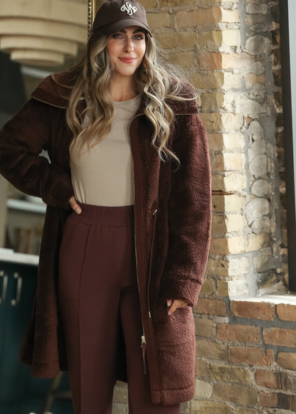 Brown Varley Melvin Club Cap with white embroidered logo styled with a burgundy sherpa coat.