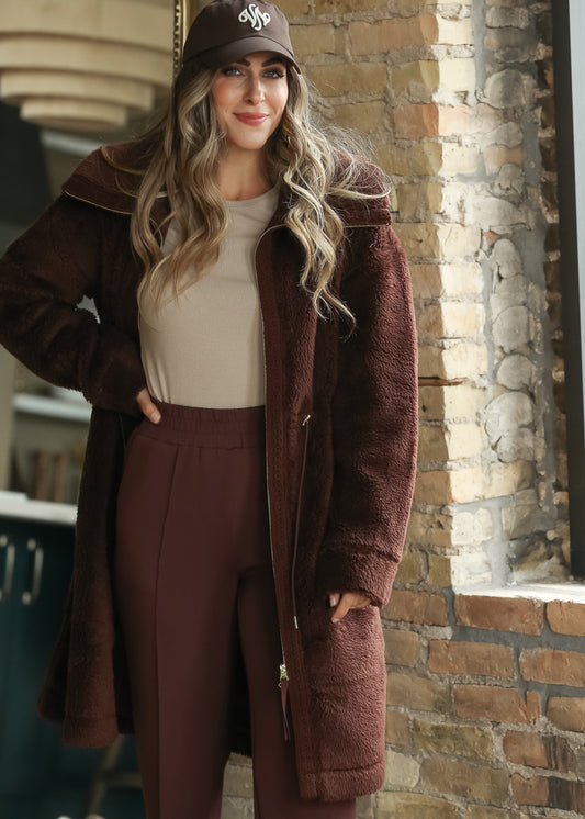 Brown Varley Melvin Club Cap with white embroidered logo styled with a burgundy sherpa coat.