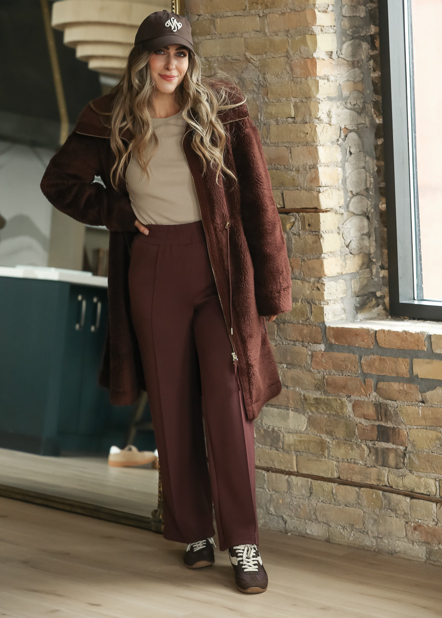 Mahogany long sherpa coat with wide collar, zip front, and knee-length silhouette.