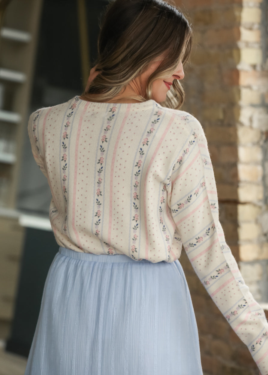 Back of cream floral stripe knit cardigan showing the vertical pink and blue pattern.