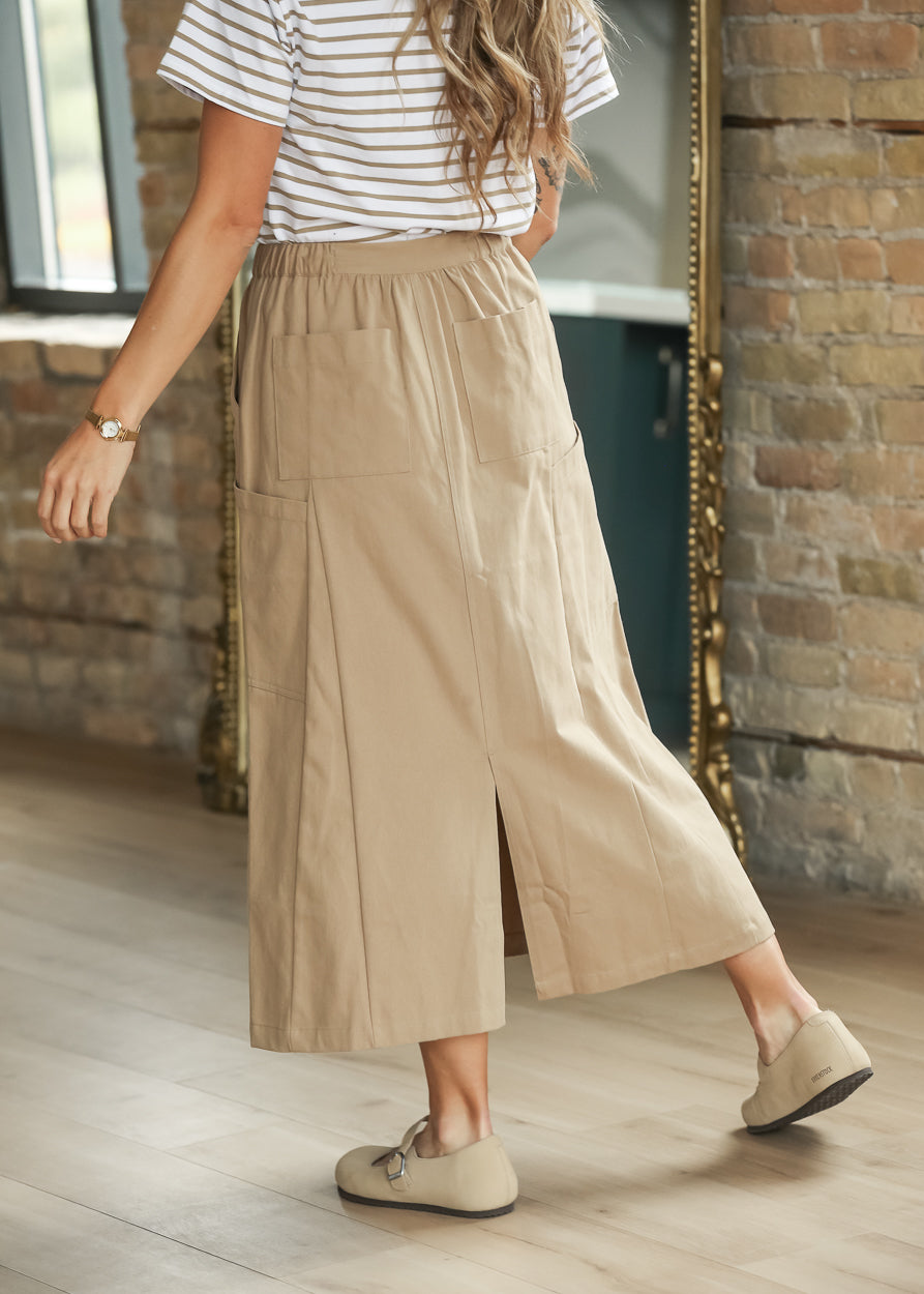 Back of taupe beige cotton midi skirt showing patch pockets and back slit.