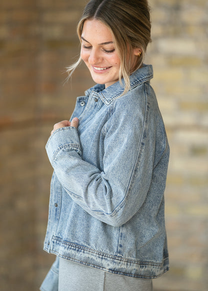 Side view of cropped denim jacket showing loose fit, long sleeves, and washed finish.