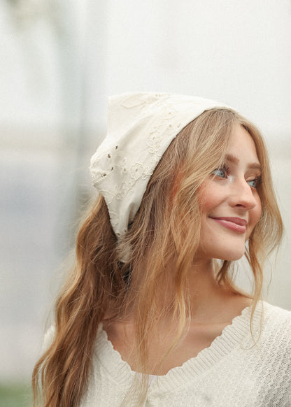 Ivory cotton floral embroidered scarf styled with loose waves and a cream knit sweater.