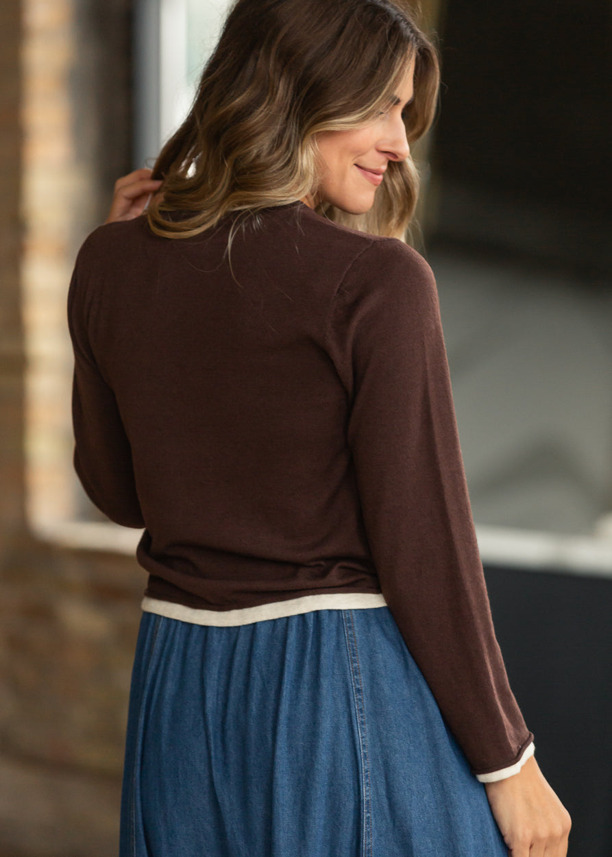 Back view of chocolate long sleeve sweater with ivory contrast hem and cuffs