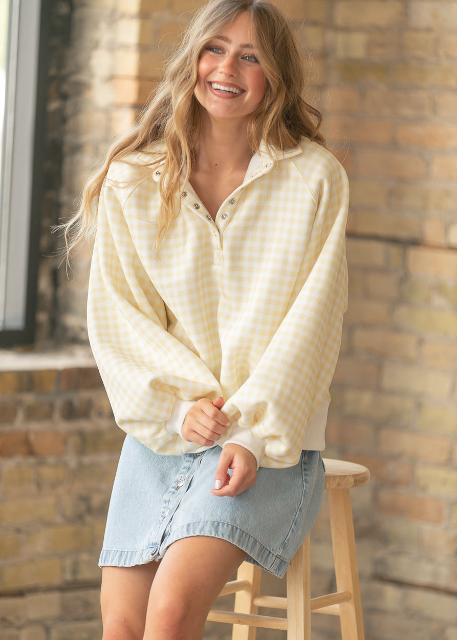 Yellow and ivory gingham pullover with collared snap neckline and relaxed everyday styling.