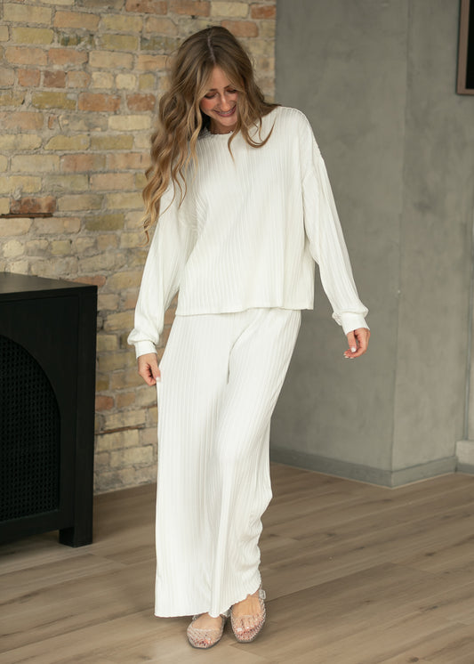 Bone white ribbed wide-leg pants showing full length and soft vertical texture.